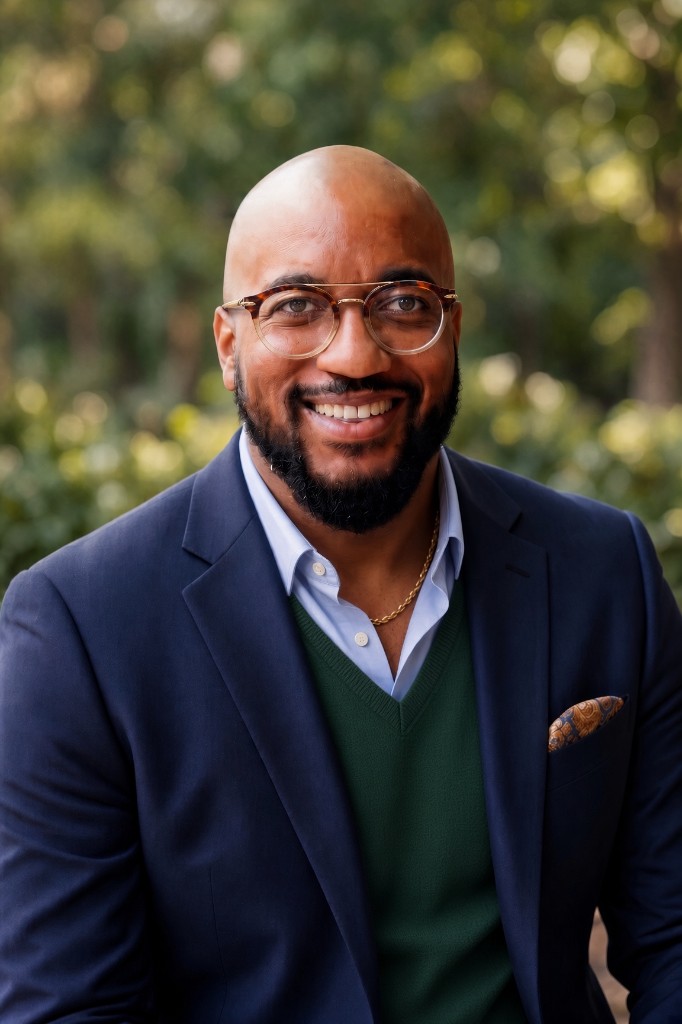 Nelson Spencer smiling, wearing glasses